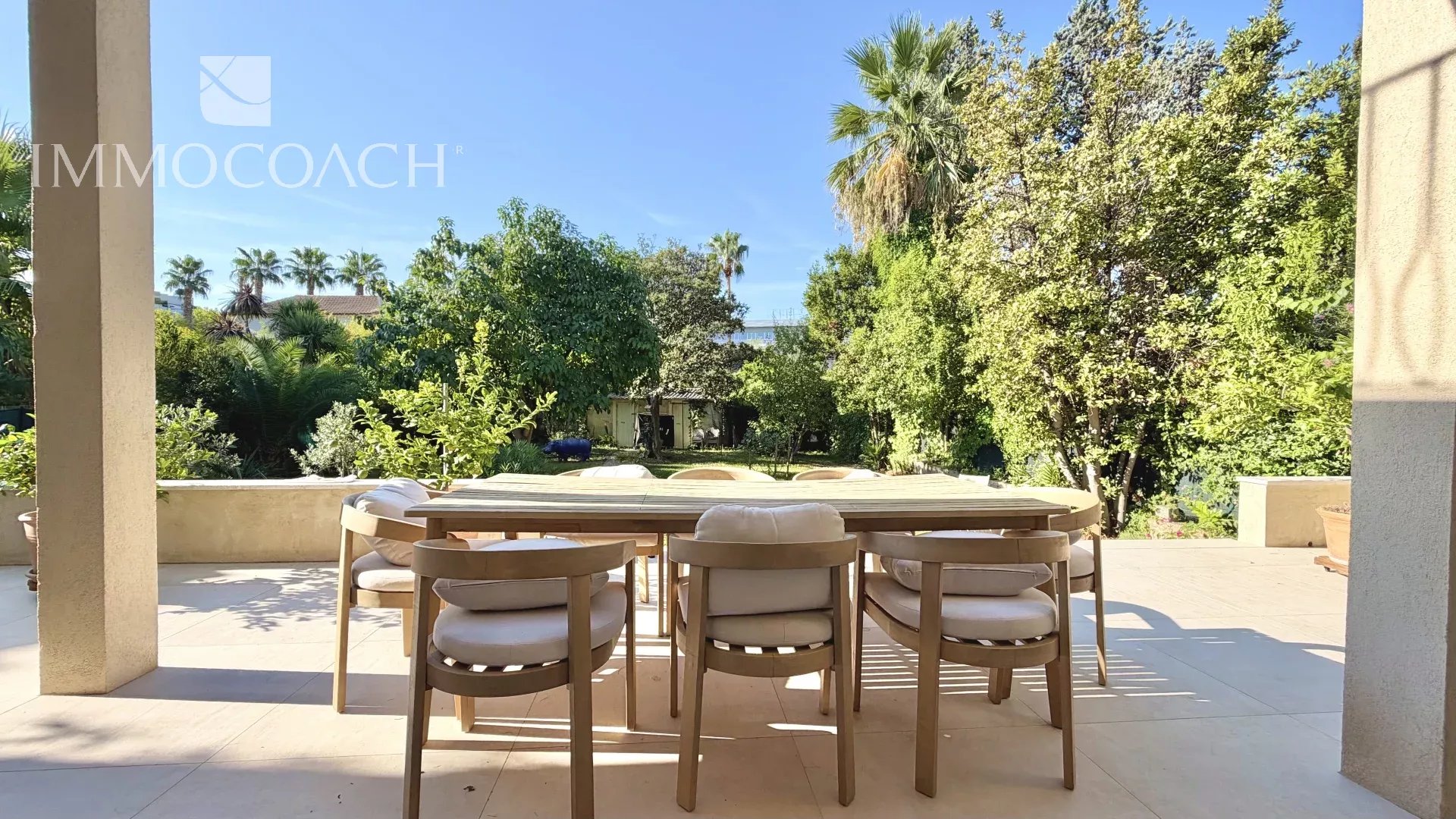 Terrasse avec vue sur jardin à Hyères Terrasse d'une maison avec table et chaises, vue sur jardin verdoyant à Hyères.