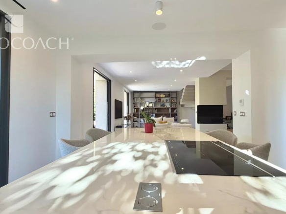 Intérieur d'une maison moderne avec cuisine américaine et séjour lumineux.