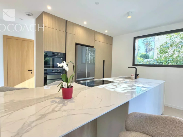 Cuisine moderne avec îlot central et équipements intégrés dans une maison rénovée à Hyères.