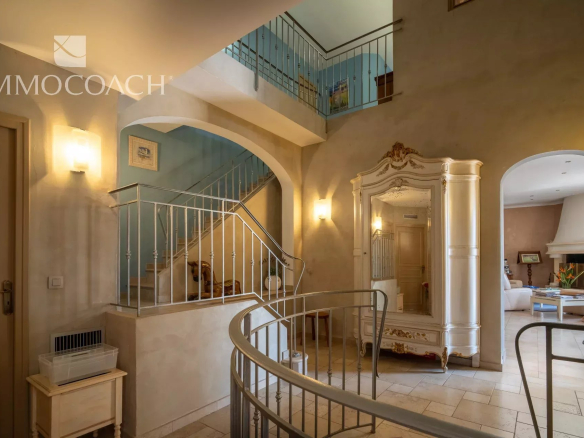 Interior of a property with a staircase and a large mirror, decorated in light colors.