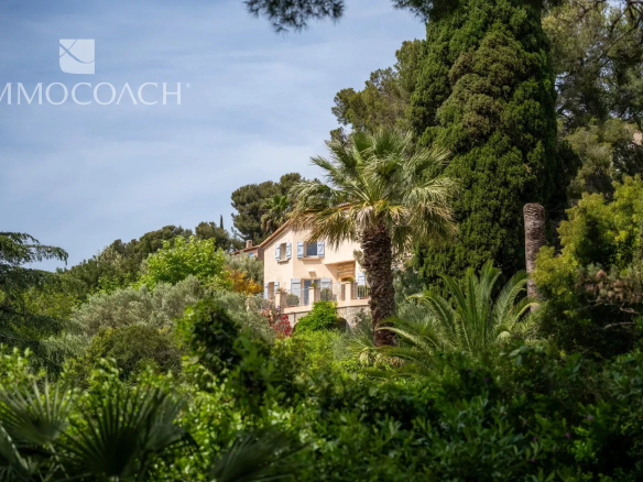Property surrounded by greenery with sea views in Carqueiranne, swimming pool visible in the garden.