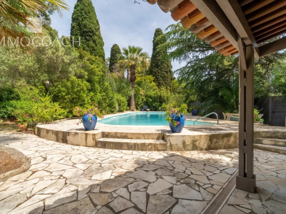 Swimming pool area surrounded by greenery in a property in Carqueiranne.