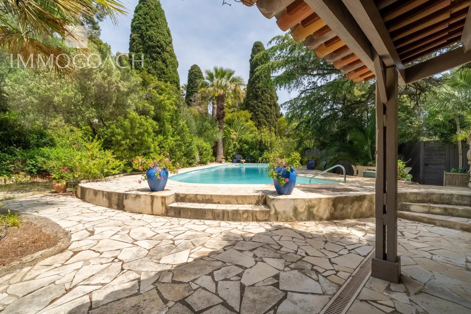 Swimming pool area surrounded by greenery in a property in Carqueiranne.