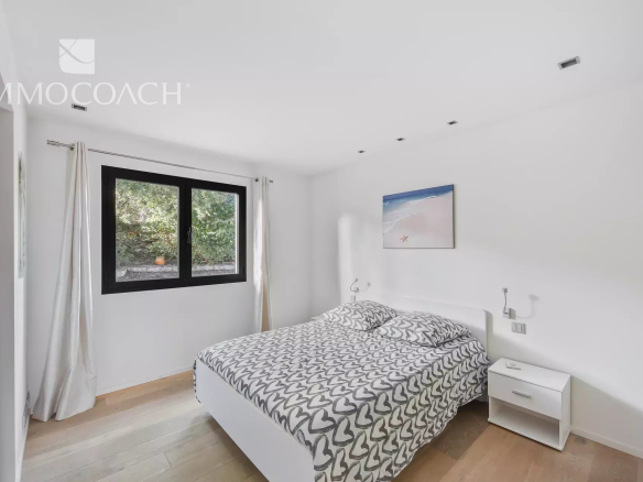 Room in a modern house with a double bed and a window overlooking the outside.