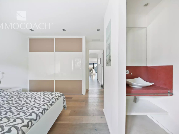 Interior of a modern bedroom with bed and en suite bathroom in a villa.