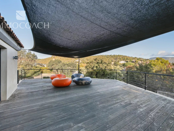 Wooden terrace with colorful armchairs and views of nature in Bormes-les-Mimosas.