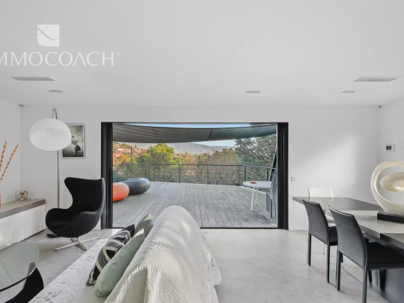 Modern interior of a villa with views of the terrace and surrounding landscape in Bormes-les-Mimosas.