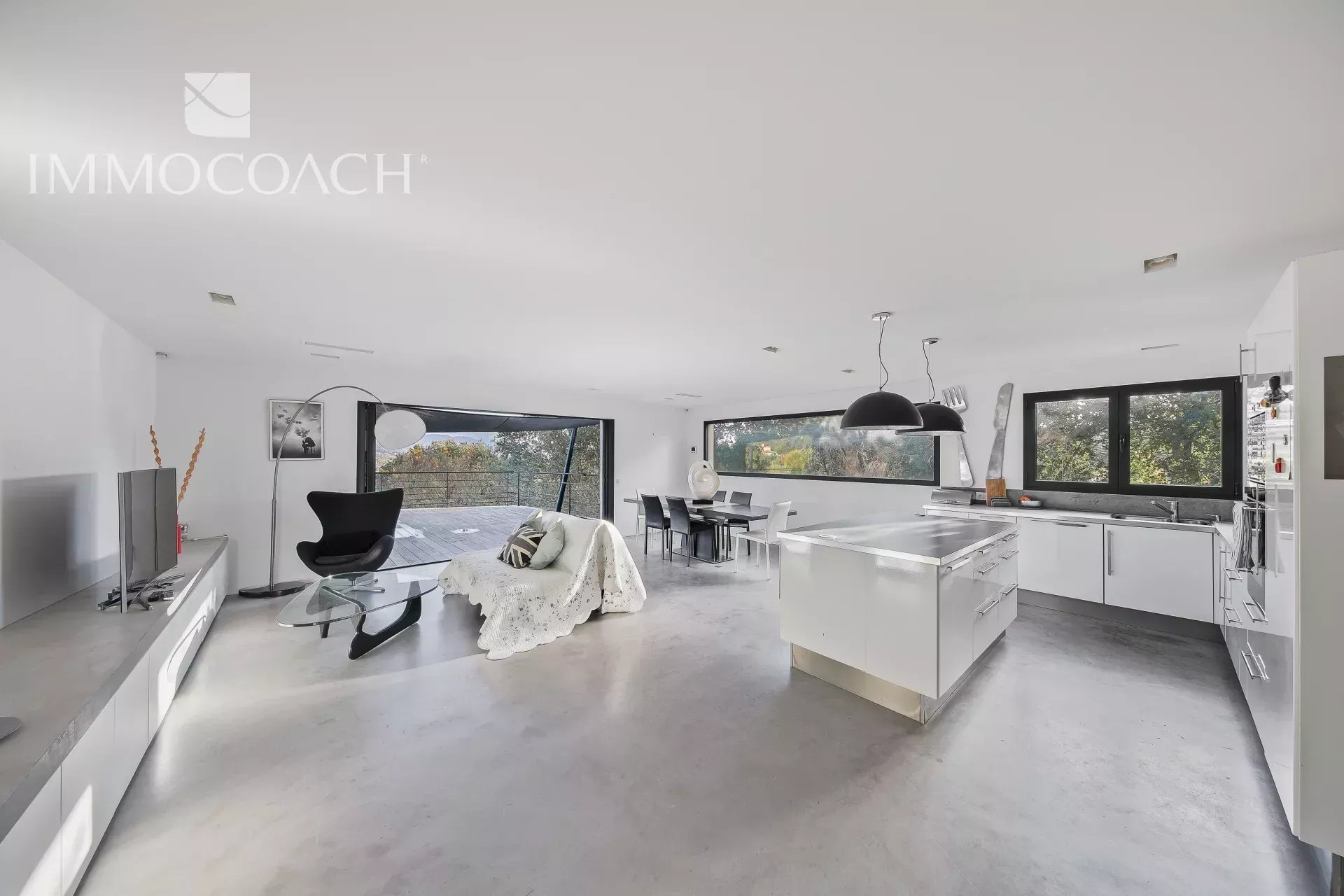 Interior of a villa in Bormes-les-Mimosas Modern villa interior with open-plan kitchen and dining area, overlooking nature