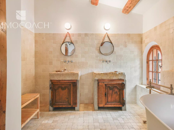Bathroom with two stone sinks and mirror in a bastide in Collobrières.