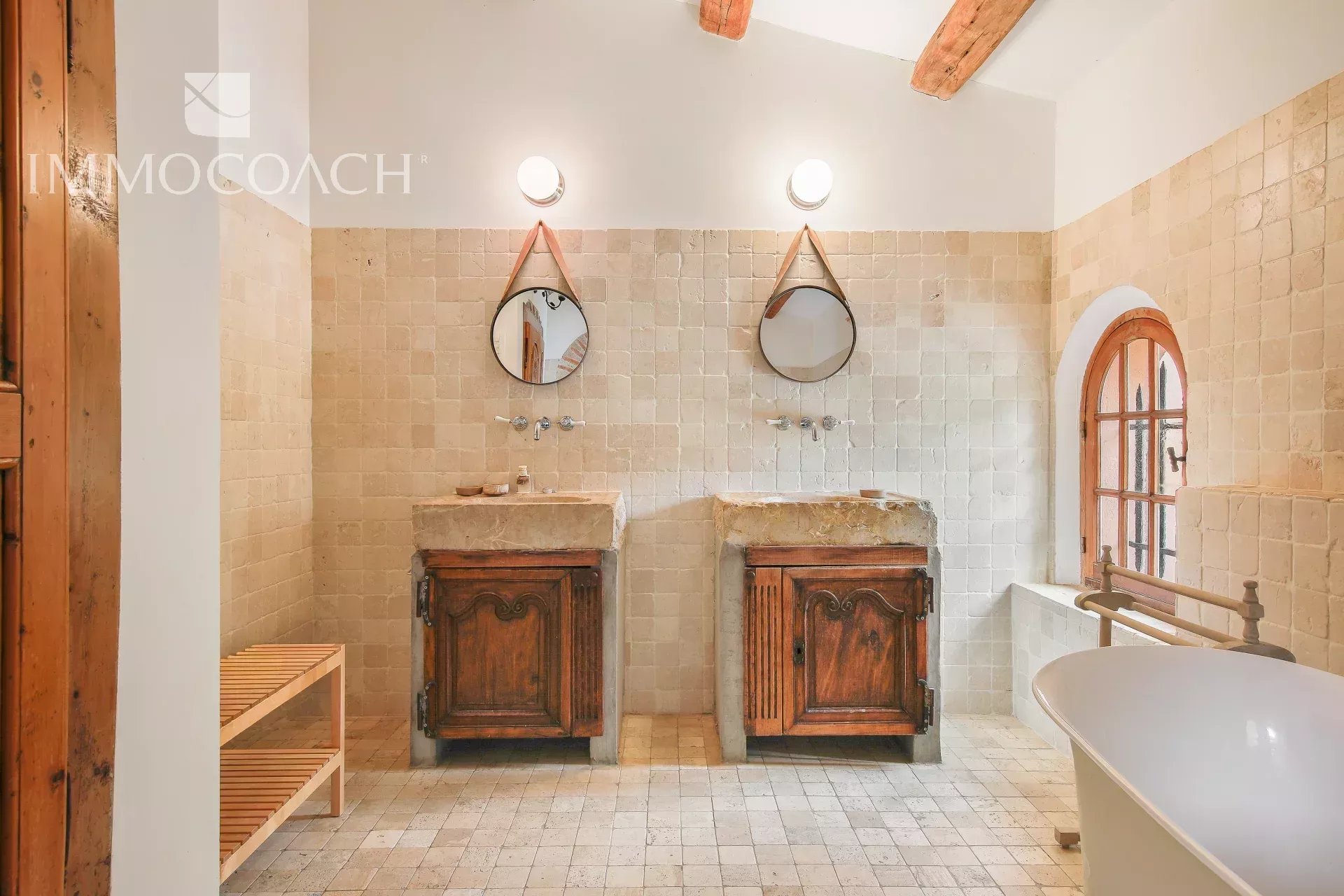 Bastide bathroom in Collobrières Bathroom with two stone sinks and mirror in a bastide in Collobrières.