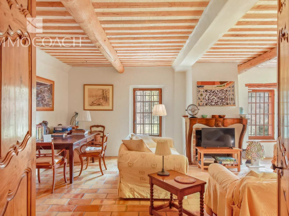 Interior of a bastide with a bright living room and an office, decorated with wooden furniture.
