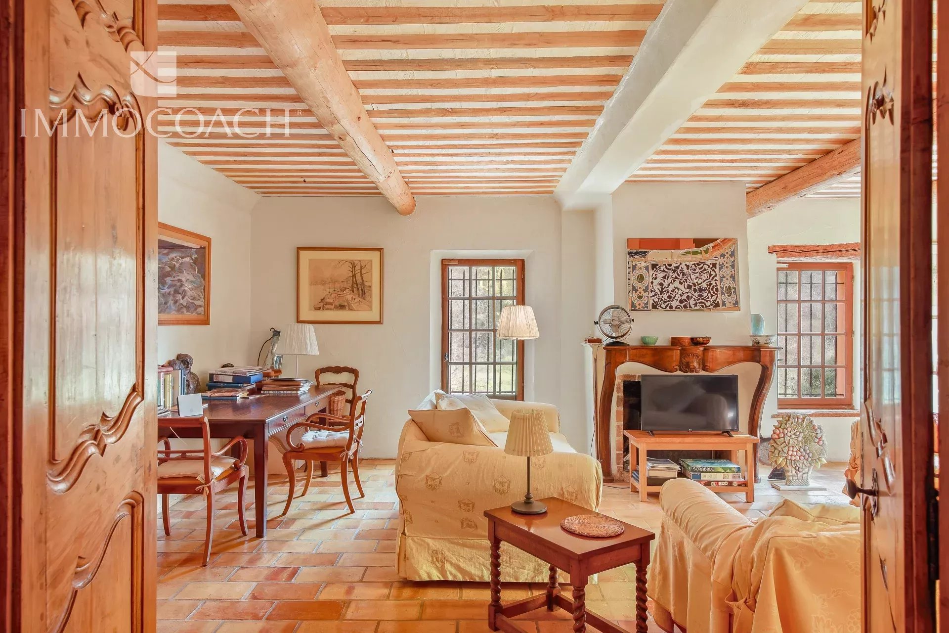 Interior of a country house in Collobrières Interior of a bastide with a bright living room and an office, decorated with wooden furniture.