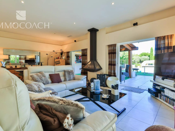 Intérieur d'une villa moderne avec salon lumineux et accès à l'extérieur.
