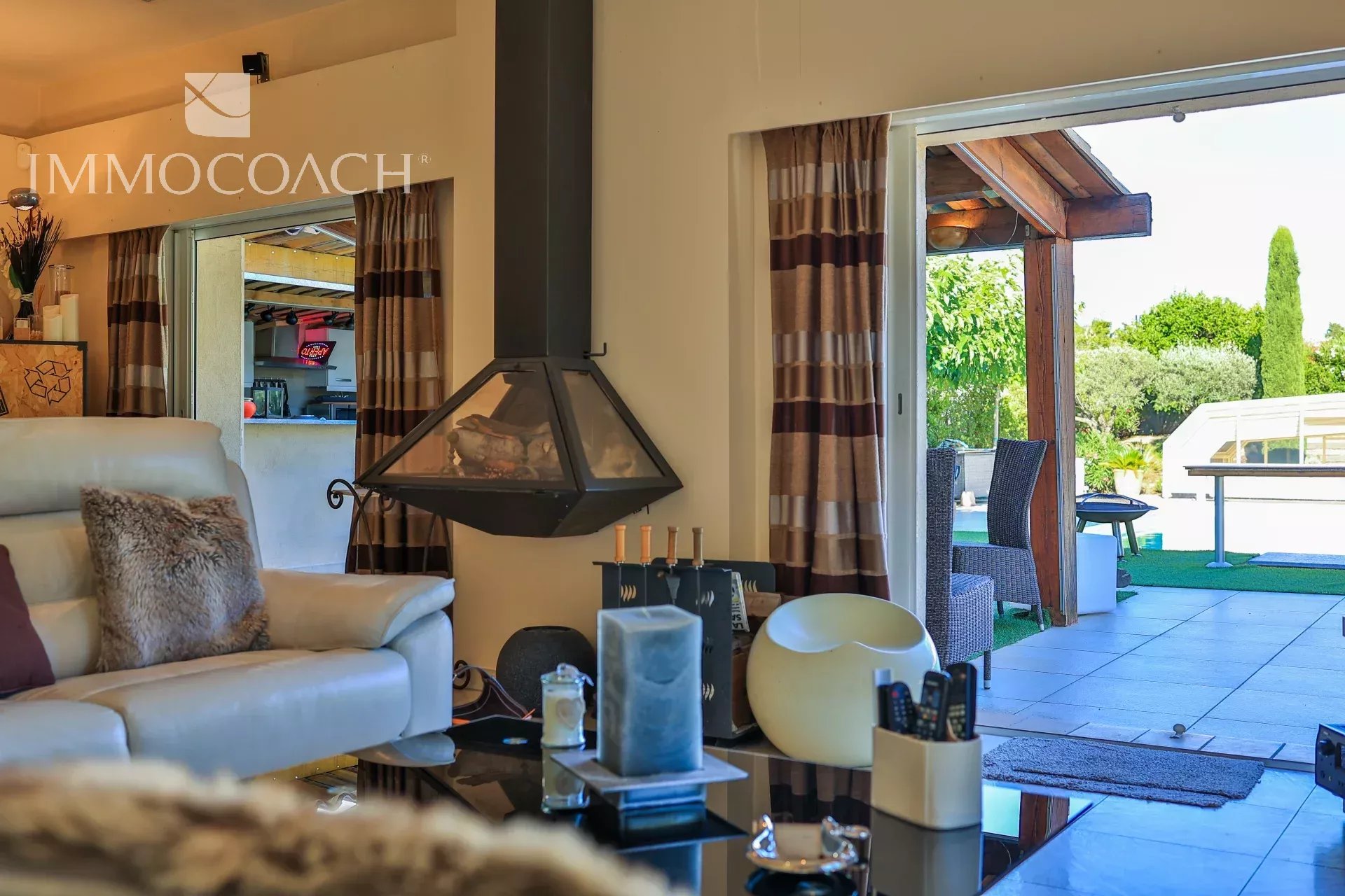 Intérieur d’une villa à Saint-Tropez Intérieur d'une villa moderne avec cheminée, salon et accès à la terrasse.
