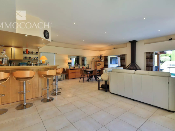 Intérieur d'une villa moderne avec salon, cuisine ouverte et bar, à Saint-Tropez.