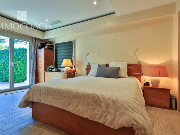 Chambre d'une villa à Saint-Tropez avec lit double et accès à l'extérieur.