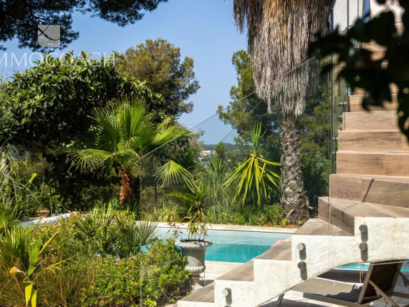 Vue d'une maison rénovée avec piscine et jardin à Carqueiranne, entourée de palmiers.