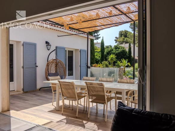 Terrasse d'une maison rénovée à Carqueiranne avec mobilier moderne et verdure.