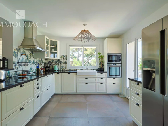 Cuisine moderne d'une maison rénovée à Carqueiranne, avec meubles clairs et équipements récents.