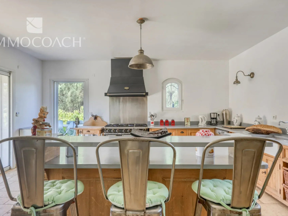 Modern kitchen with bar and chairs in a neo-Provençal villa in Bormes-les-Mimosas.