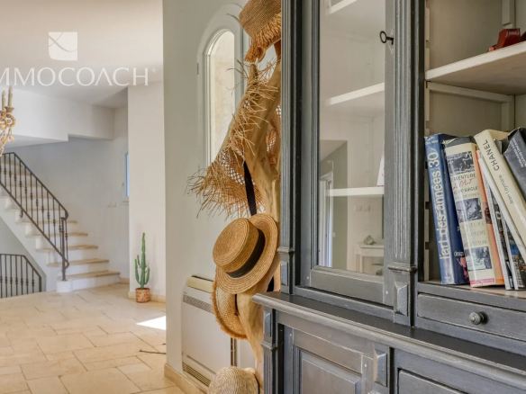 Interior of a neo-Provençal villa with elegant decoration and hats hanging on the walls.