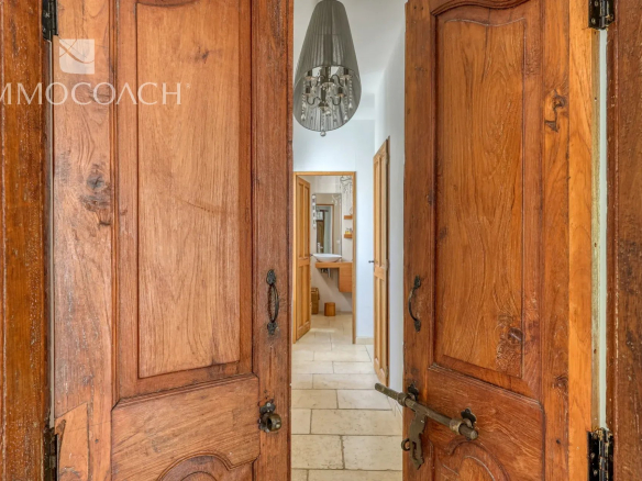 Entrance to a neo-Provençal villa with wooden doors, view of a corridor