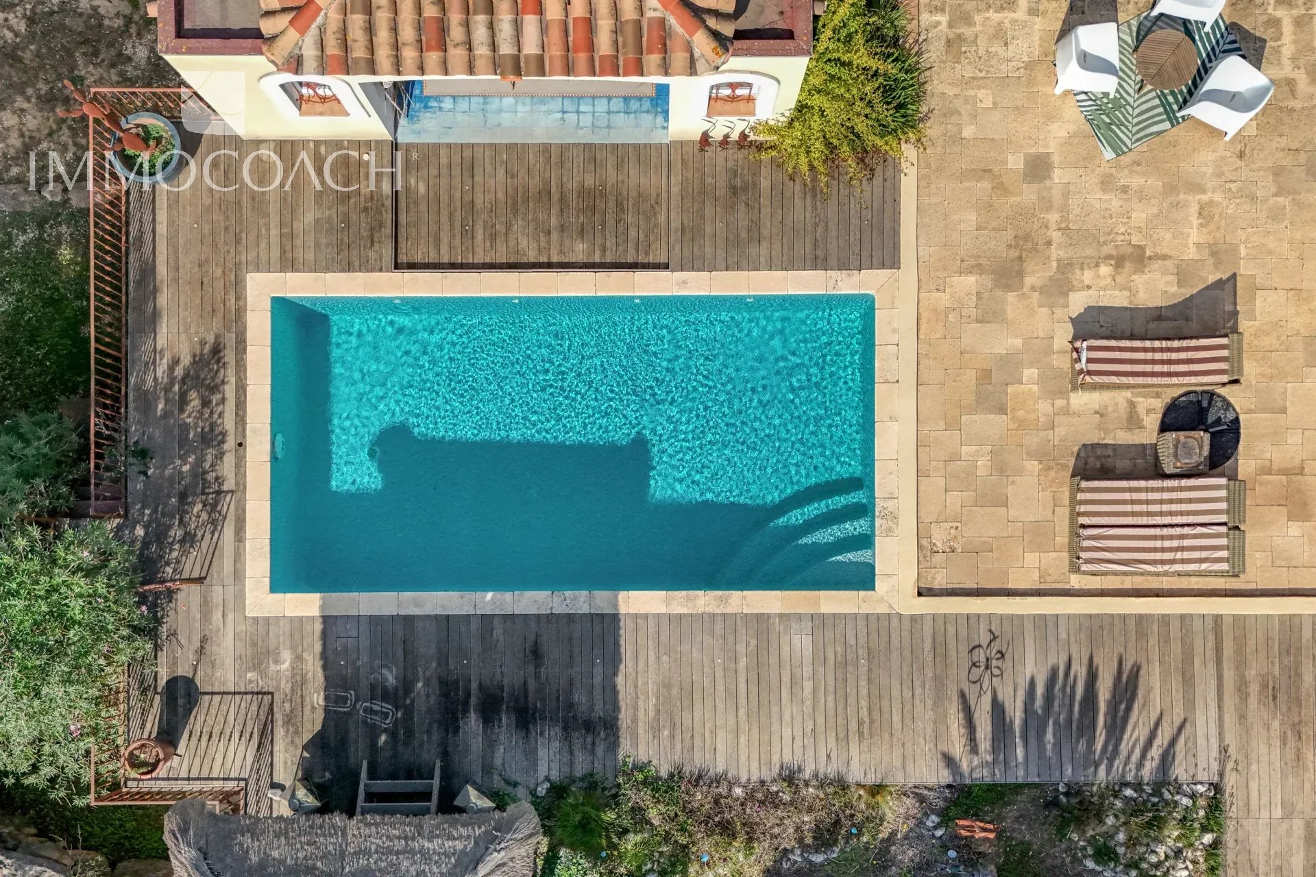 Neo-Provençal villa with swimming pool Aerial view of the swimming pool of a neo-Provençal villa with a wooden terrace in Bormes-les-Mimosas.