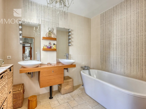 Modern bathroom with bathtub and double sink in a neo-Provençal villa.