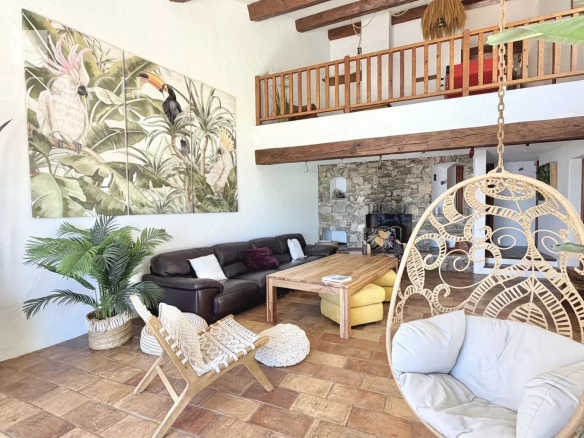 Intérieur d'une villa lumineuse avec salon, mezzanine et décoration tropicale à Carqueiranne.