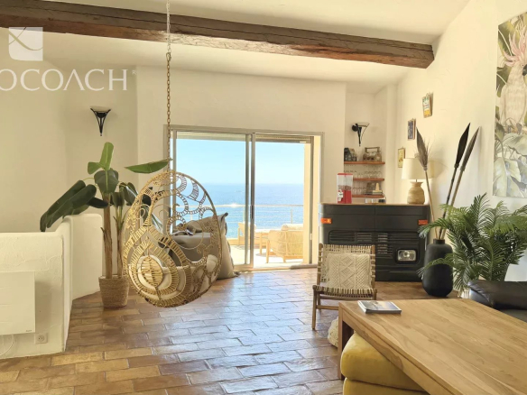 Intérieur d'une villa lumineuse avec vue sur la mer à Carqueiranne, incluant un salon et une terrasse.