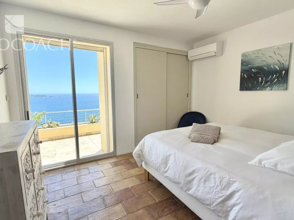 Chambre avec vue sur la mer à Carqueiranne, fenêtre ouverte sur un paysage marin.