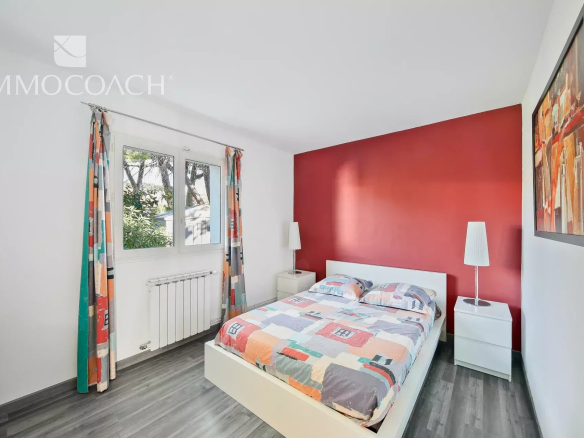 Chambre d'une villa à Carqueiranne avec lit double et décoration colorée.