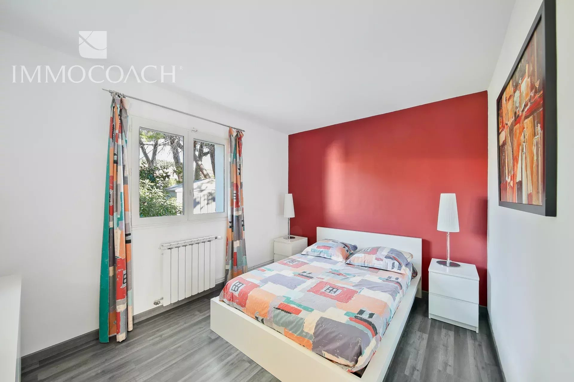 Chambre de villa à Carqueiranne Chambre d'une villa à Carqueiranne avec lit double et décoration colorée.