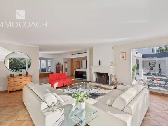 Intérieur d'une villa à Carqueiranne avec salon lumineux et cheminée.