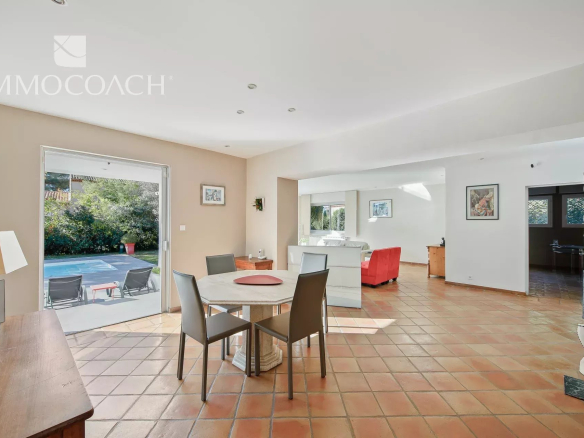 Intérieur d'une villa à Carqueiranne avec salle à manger et vue sur le jardin et la piscine.