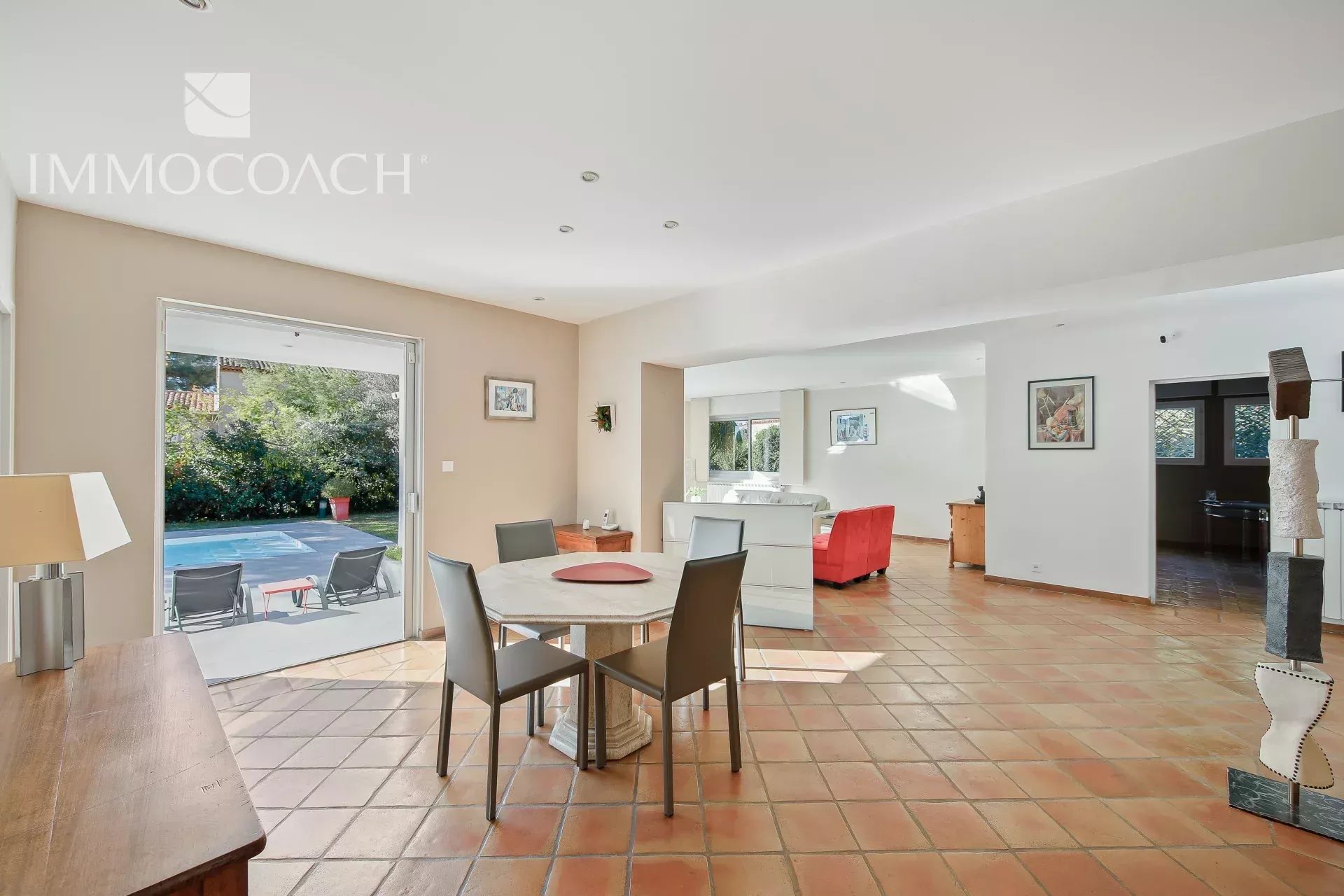 Intérieur de villa à Carqueiranne Intérieur d'une villa à Carqueiranne avec salle à manger et vue sur le jardin et la piscine.