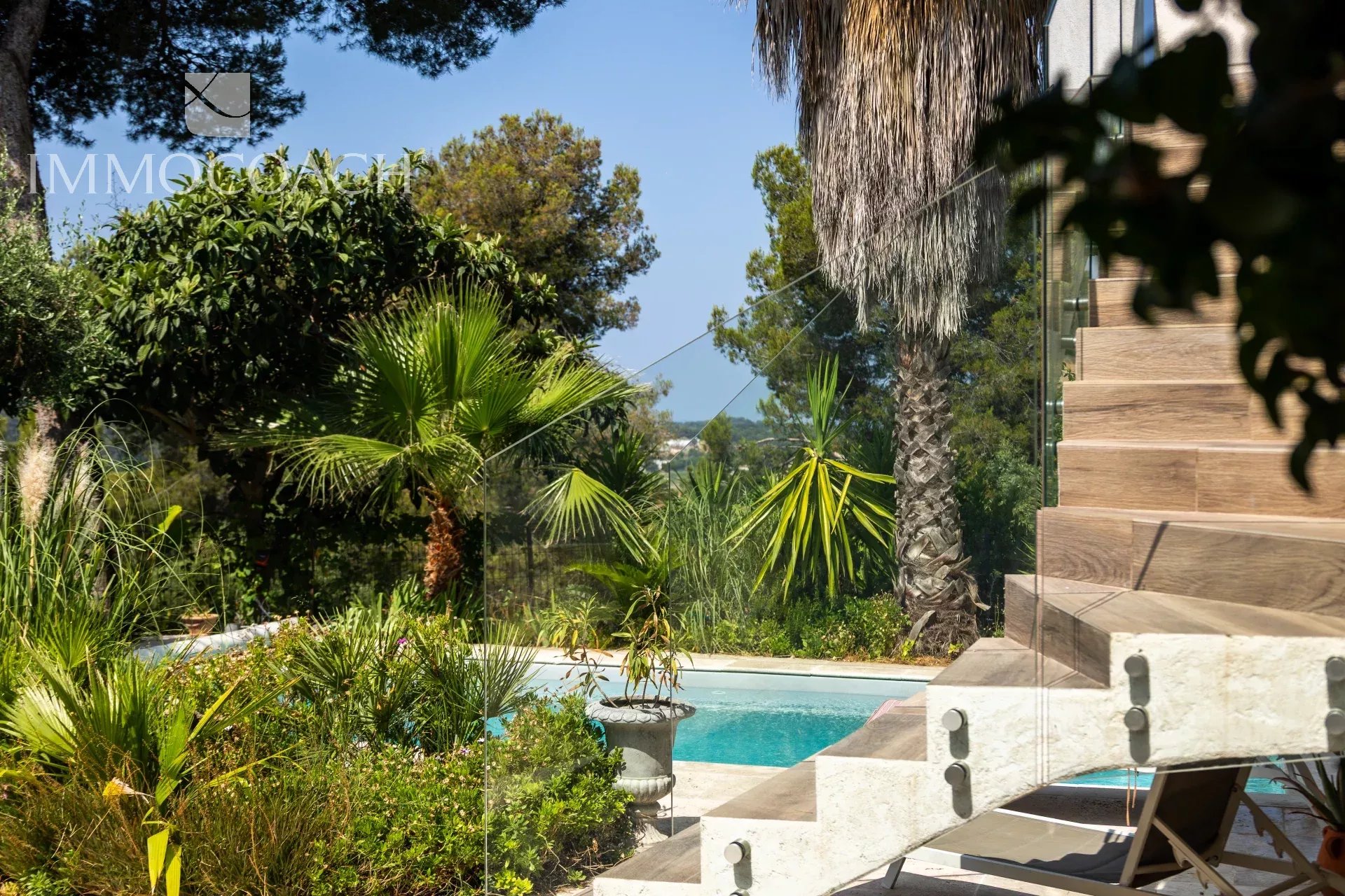 Renovated house in Carqueiranne View of a renovated house with swimming pool and garden in Carqueiranne, surrounded by palm trees.