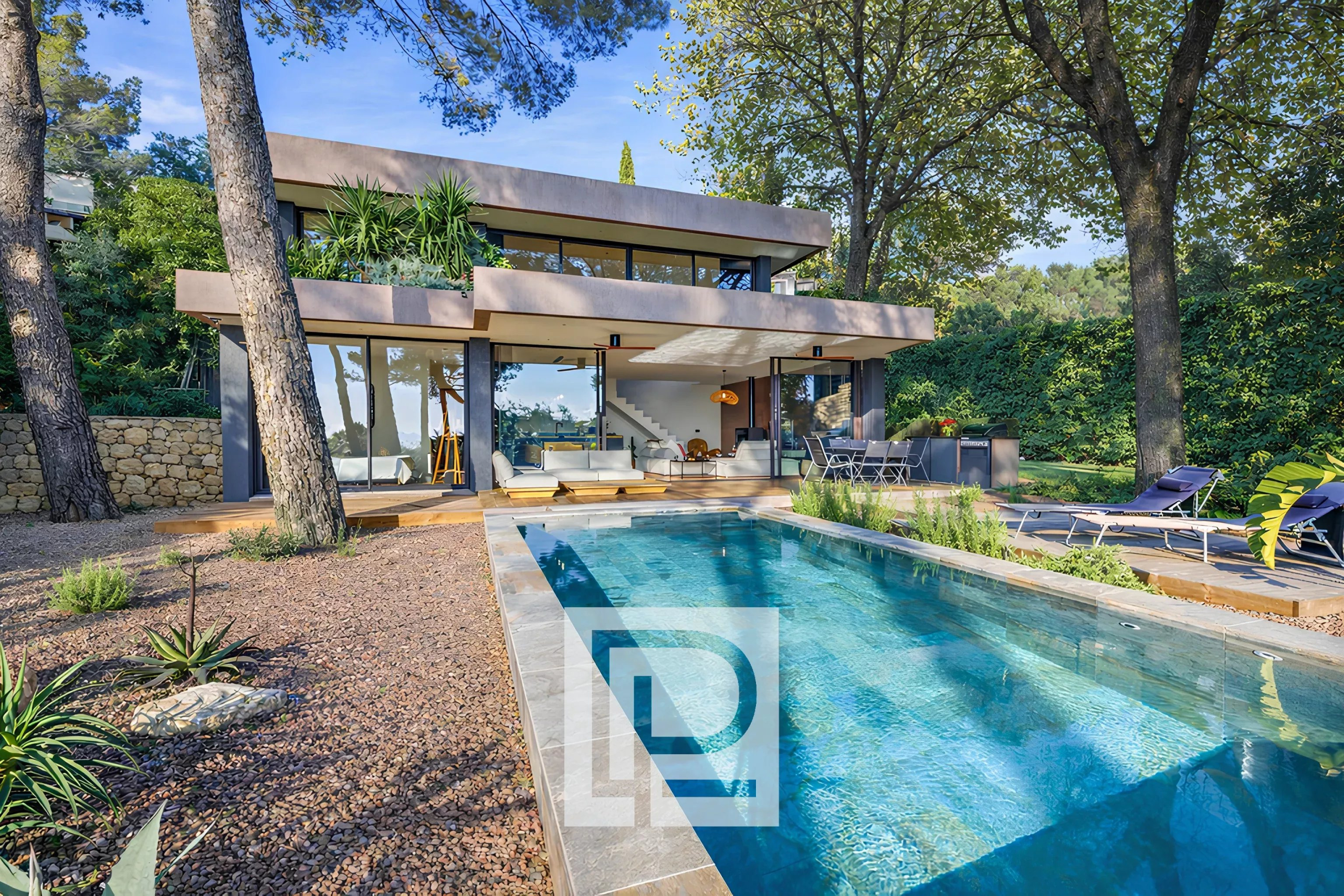 Modern two-story house with glass walls, open-plan living area, and a rectangular in-ground pool surrounded by a gravel yard and trees.
