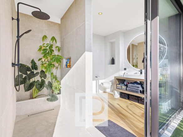 Modern bathroom with an open shower, large rainfall showerhead, and leafy plants in a built-in niche.