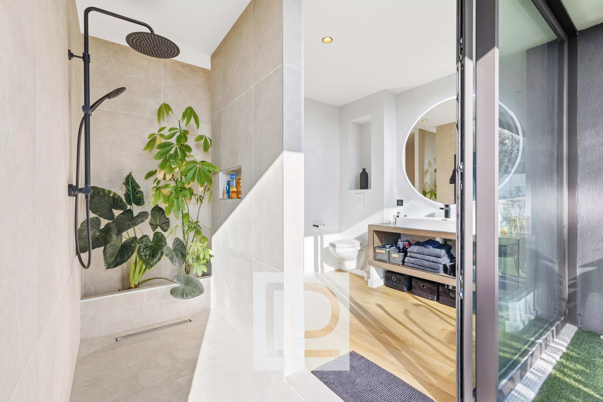 Modern bathroom with an open shower, large rainfall showerhead, and leafy plants in a built-in niche.