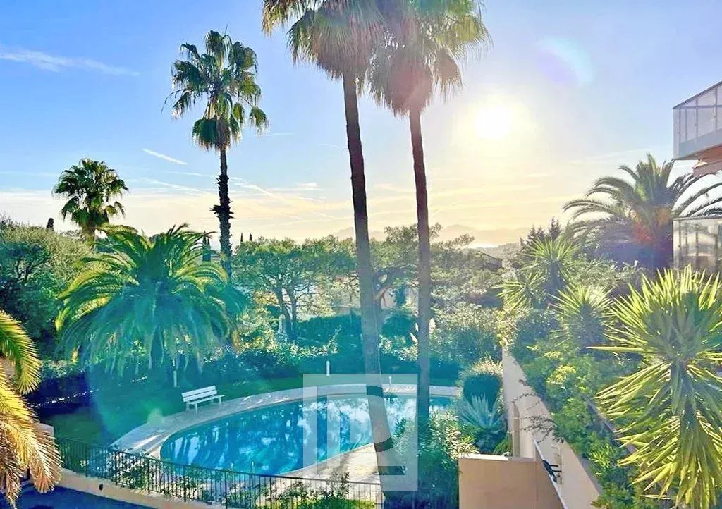 Vue depuis un appartement au Cannet Vue sur la piscine et les palmiers dans un quartier résidentiel au Cannet, avec ciel ensoleillé.
