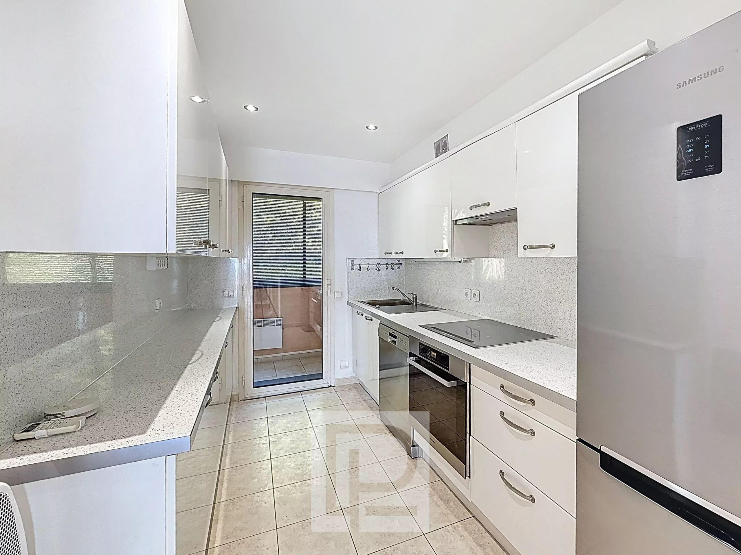 Cuisine d’un appartement au Cannet Cuisine moderne et lumineuse d'un appartement avec accès à une terrasse.