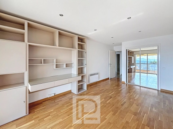 Intérieur d'un appartement lumineux avec un espace de vie ouvert et un accès à une terrasse.