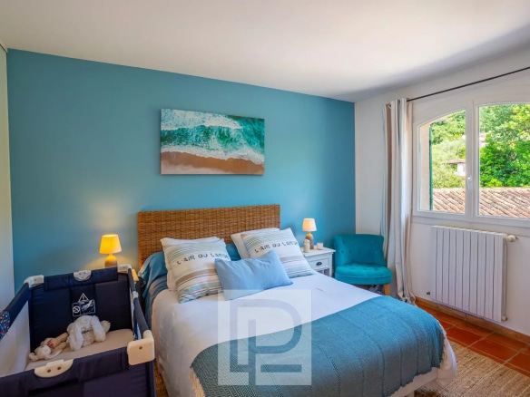 Chambre d'une villa provençale rénovée avec lit et décoration lumineuse à Mougins.