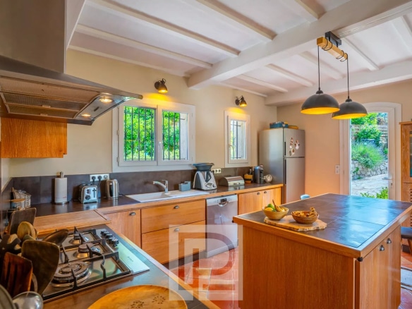 Cuisine d'une villa provençale rénovée avec îlot central et équipements modernes.