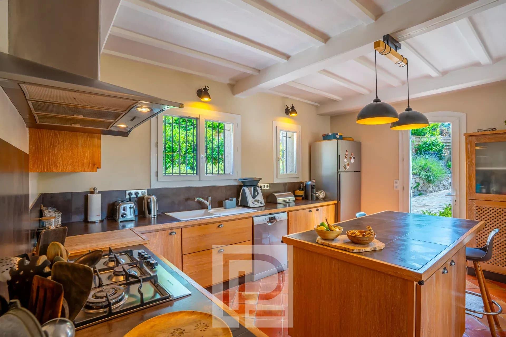 Cuisine d’une villa à Mougins Cuisine d'une villa provençale rénovée avec îlot central et équipements modernes.