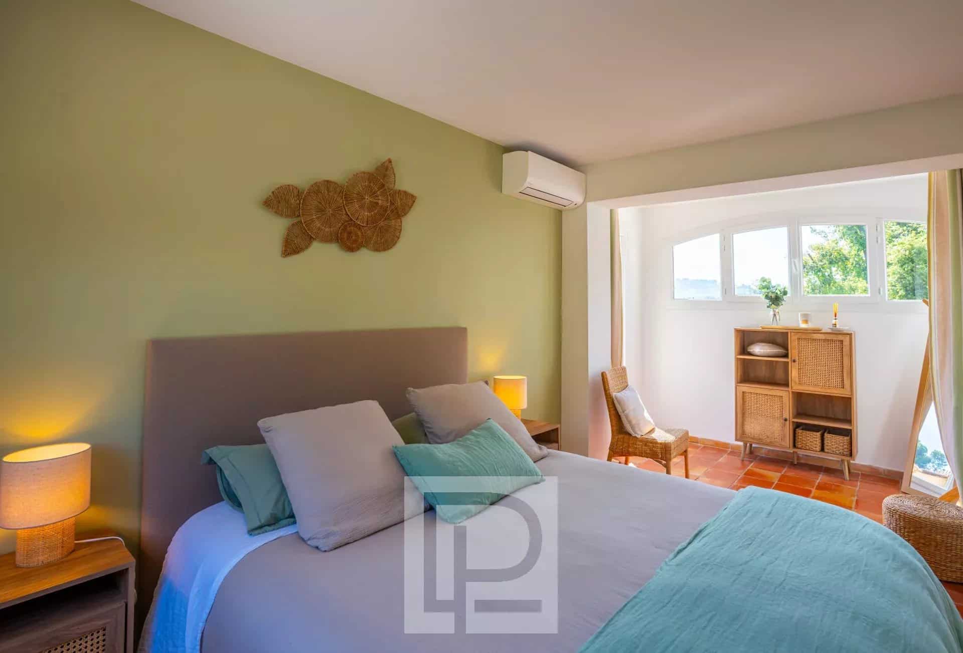 Chambre de villa provençale à Mougins Chambre d'une villa provençale rénovée avec des murs verts et des meubles en bois à Mougins.