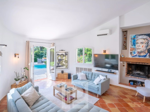 Intérieur d'une villa provençale rénovée avec salon lumineux et cheminée.