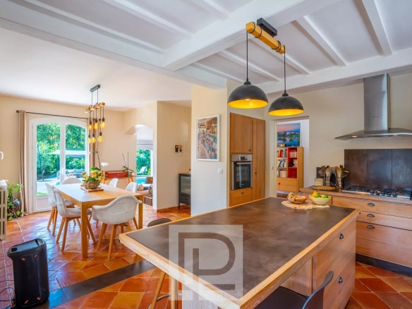 Intérieur d'une villa provençale rénovée avec cuisine ouverte et salle à manger.