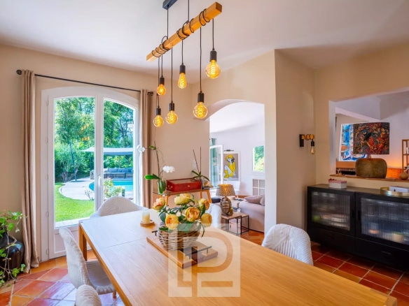 Intérieur d'une villa provençale rénovée avec salle à manger lumineuse et vue sur le jardin.